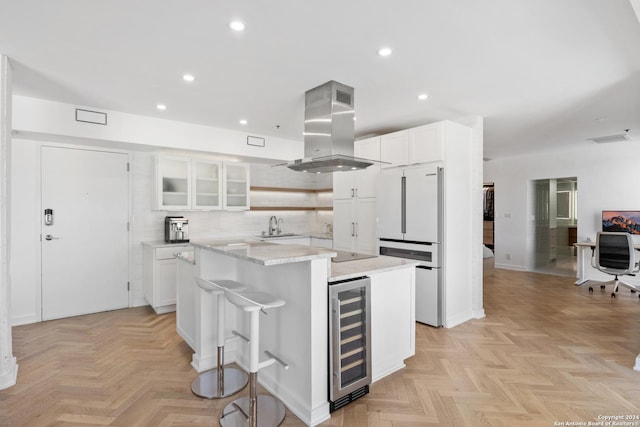 kitchen with beverage cooler, island range hood, white cabinets, glass insert cabinets, and open shelves