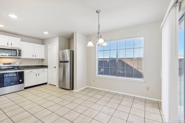 kitchen featuring white cabinets, hanging light fixtures, light tile patterned floors, appliances with stainless steel finishes, and a notable chandelier