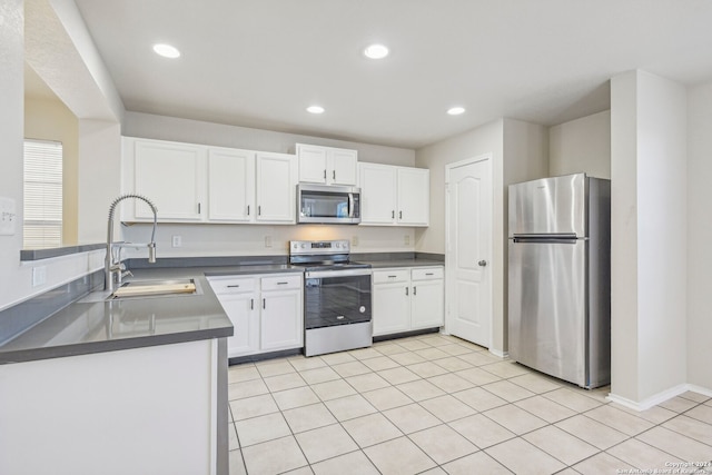 kitchen featuring light tile patterned floors, stainless steel appliances, white cabinetry, and sink