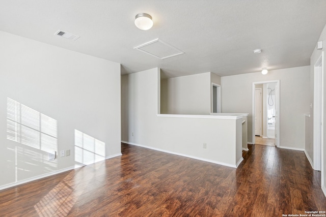 unfurnished living room with a textured ceiling and dark hardwood / wood-style floors