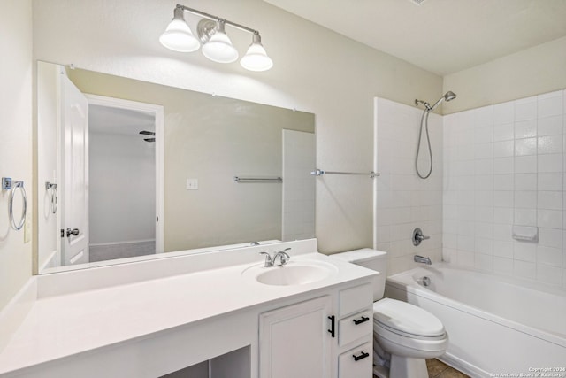 full bathroom with vanity, tiled shower / bath combo, toilet, and ceiling fan