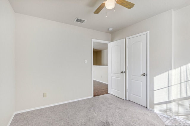 unfurnished bedroom featuring ceiling fan and light carpet