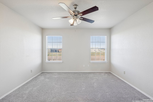 carpeted spare room with plenty of natural light and ceiling fan