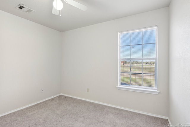 carpeted spare room featuring ceiling fan