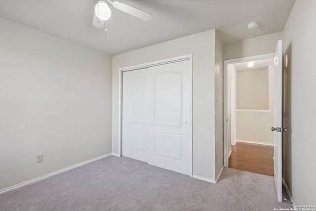 unfurnished bedroom with light carpet, a closet, and ceiling fan