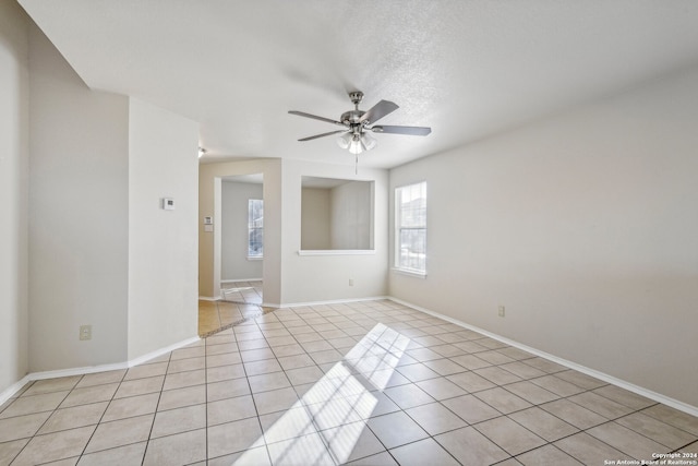 spare room featuring light tile patterned floors, a textured ceiling, and ceiling fan