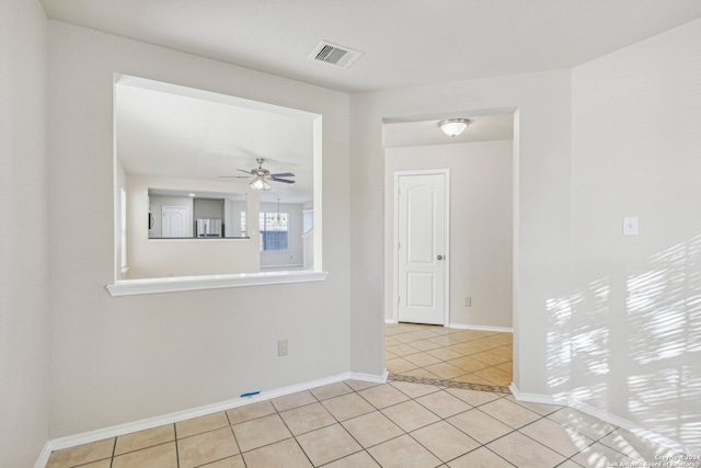 spare room with ceiling fan and light tile patterned flooring