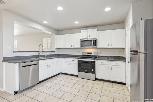 kitchen featuring sink, white cabinets, stainless steel appliances, and light tile patterned floors