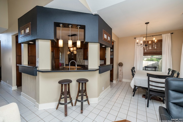 kitchen with kitchen peninsula, a breakfast bar, pendant lighting, a chandelier, and light tile patterned flooring