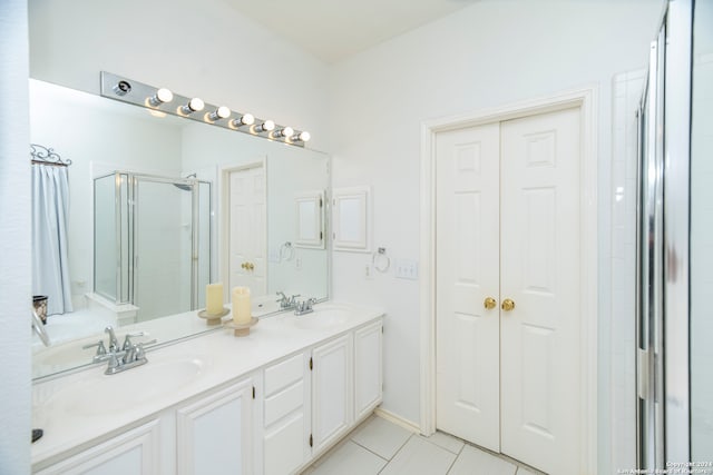 bathroom featuring a shower with door, vanity, and tile patterned flooring