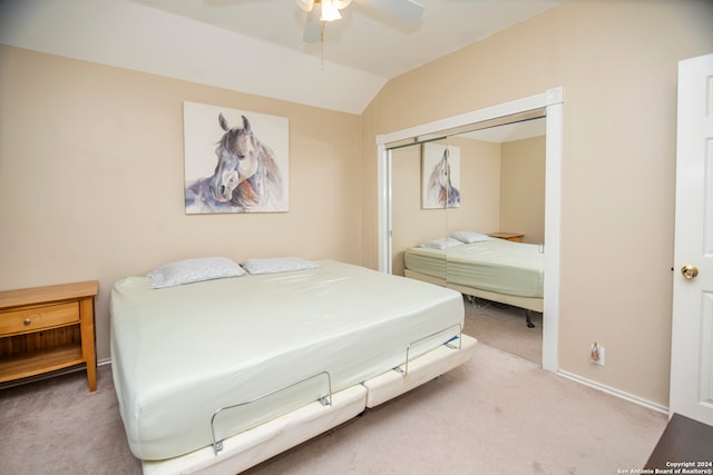 bedroom with carpet flooring, ceiling fan, a closet, and vaulted ceiling