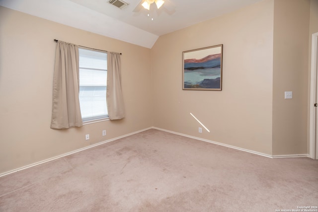 empty room with light carpet, vaulted ceiling, and ceiling fan