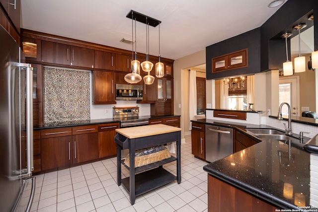 kitchen featuring decorative light fixtures, sink, appliances with stainless steel finishes, and an inviting chandelier