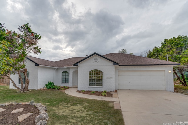 ranch-style house with a garage and a front yard