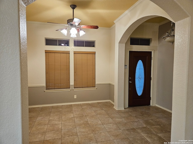 tiled entrance foyer featuring ceiling fan and ornamental molding