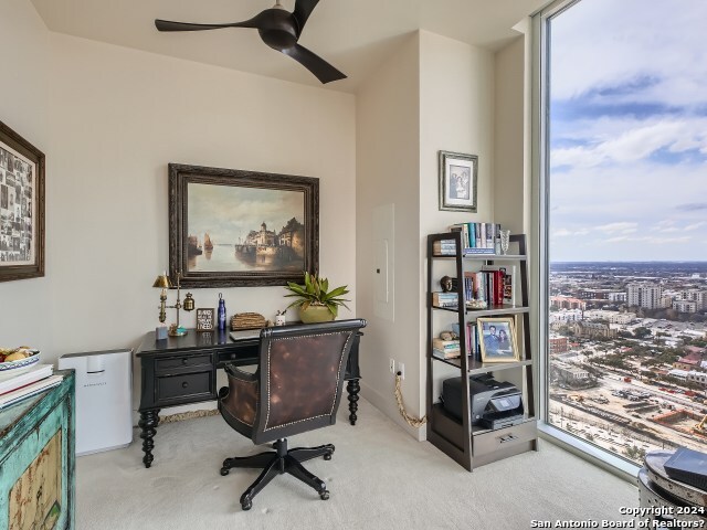 office space with ceiling fan and light carpet