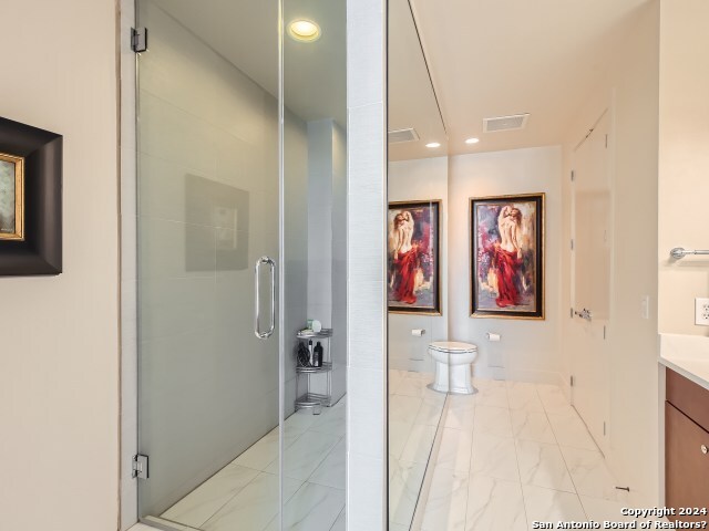 bathroom featuring walk in shower, vanity, and toilet