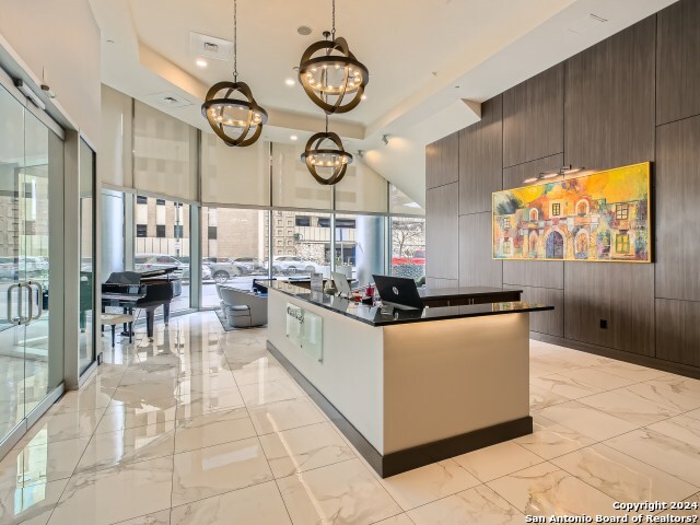 kitchen with pendant lighting, wood walls, dark brown cabinetry, and a high ceiling