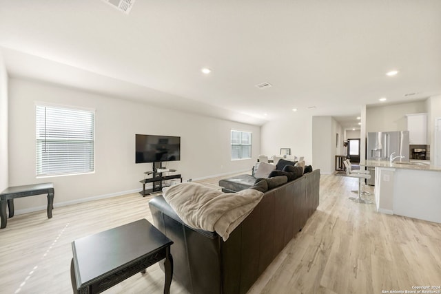 living room featuring light wood-type flooring and sink