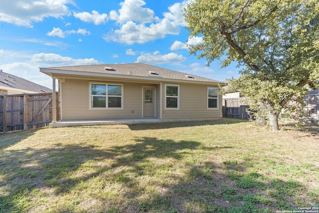 rear view of house featuring a lawn and a patio area