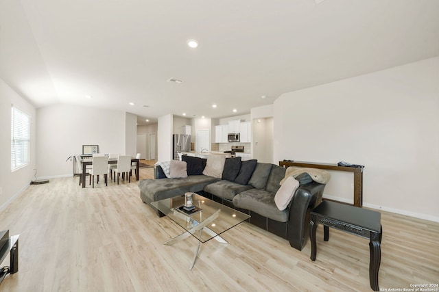 living room featuring light hardwood / wood-style floors and lofted ceiling