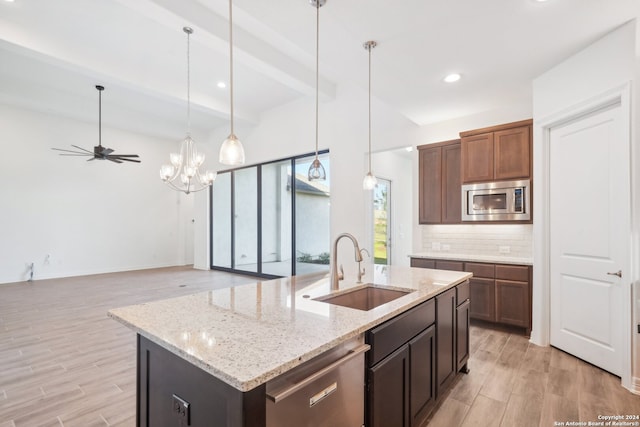 kitchen featuring sink, a center island with sink, appliances with stainless steel finishes, beamed ceiling, and decorative backsplash