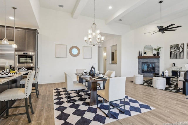 23422 Grande Vis, San Antonio, TX 78261 - dining area with beamed ceiling, light wood-style flooring, a fireplace, ceiling fan, and a towering ceiling