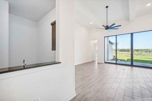 spare room featuring ceiling fan and beamed ceiling