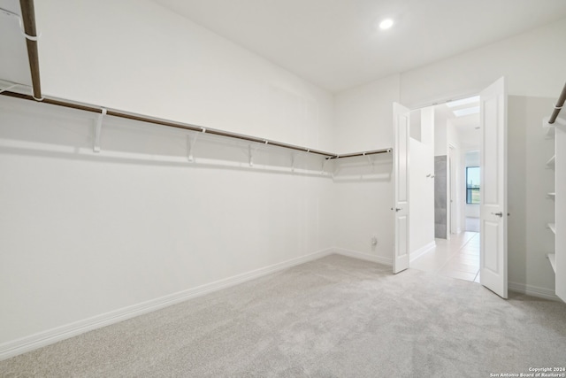 walk in closet featuring light colored carpet