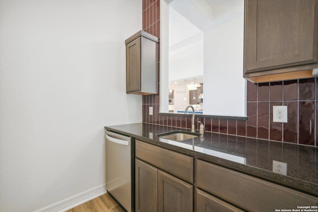 23422 Grande Vis, San Antonio, TX 78261 - kitchen featuring dishwasher, a sink, decorative backsplash, dark stone counters, and baseboards