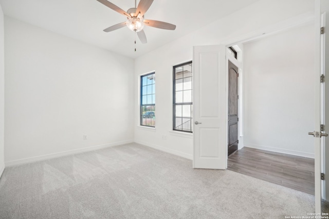 unfurnished room with light colored carpet and ceiling fan