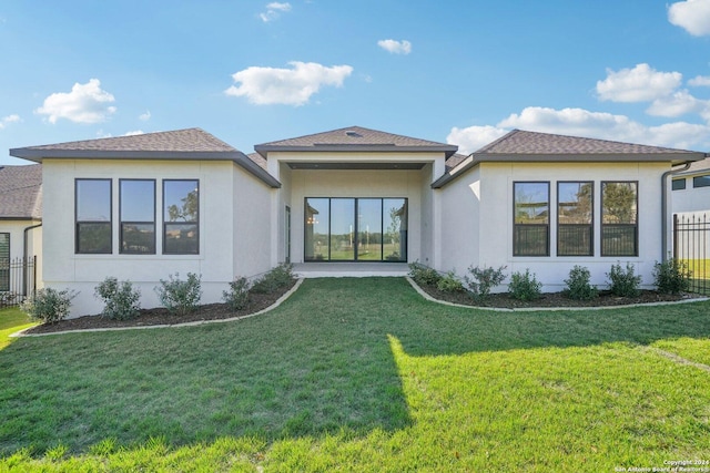 rear view of property featuring a lawn