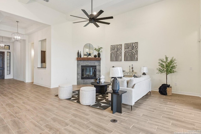 23422 Grande Vis, San Antonio, TX 78261 - living room with baseboards, light wood finished floors, a tiled fireplace, ceiling fan, and a chandelier