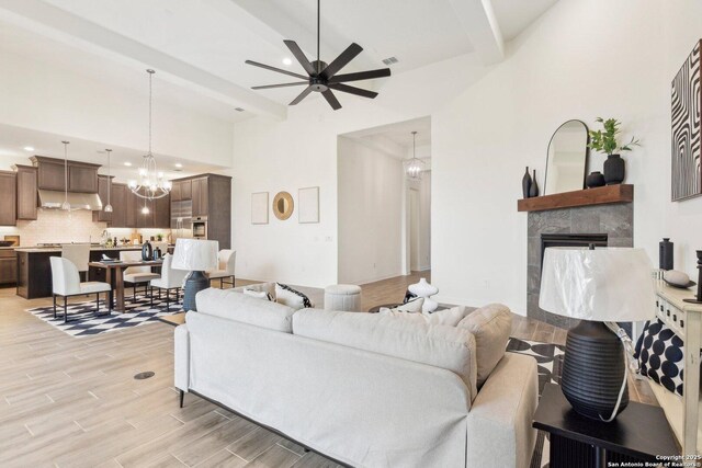 23422 Grande Vis, San Antonio, TX 78261 - living area featuring beamed ceiling, ceiling fan, light wood finished floors, a chandelier, and a tiled fireplace