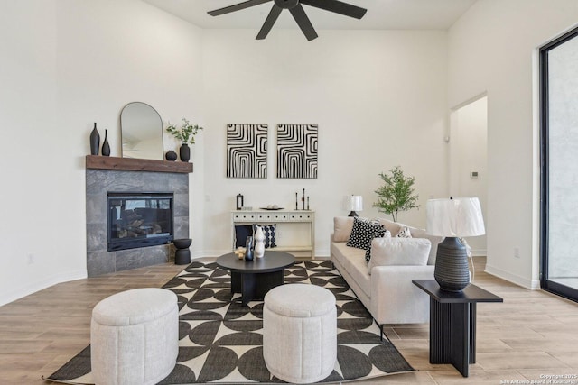 23422 Grande Vis, San Antonio, TX 78261 - living area with ceiling fan, wood finished floors, a towering ceiling, a fireplace, and baseboards