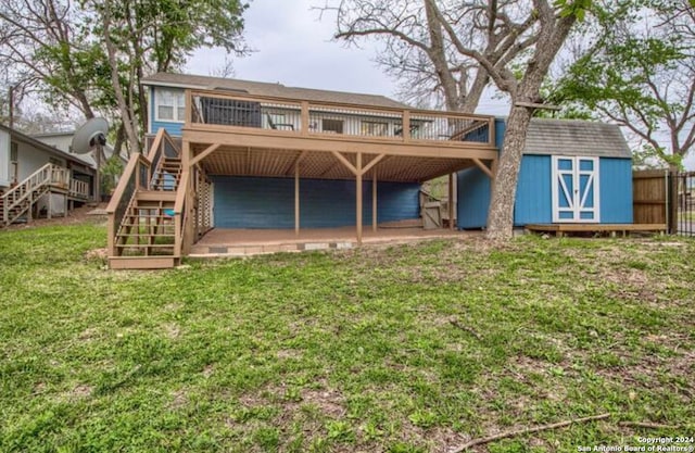 back of property with a lawn, a storage unit, and a deck