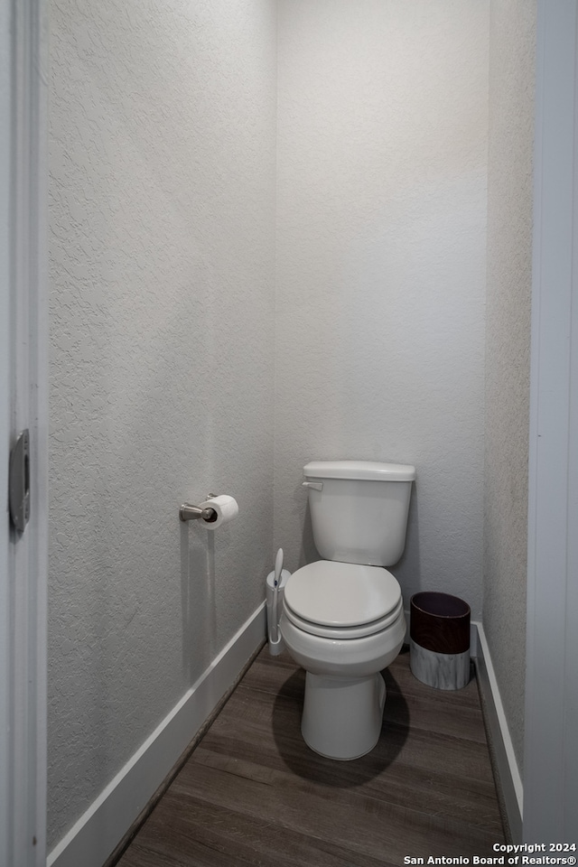 bathroom with toilet and wood-type flooring