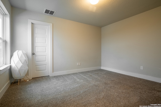 carpeted empty room featuring a textured ceiling