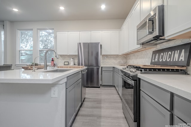 kitchen featuring tasteful backsplash, sink, an island with sink, and appliances with stainless steel finishes