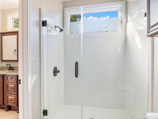 bathroom with tile patterned floors, vanity, a shower with door, and crown molding