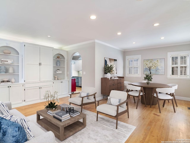 living room with crown molding and light hardwood / wood-style floors