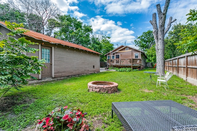 view of yard with a deck and an outdoor fire pit