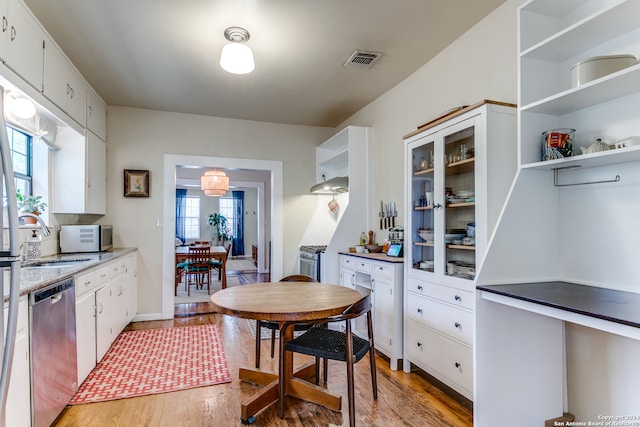 kitchen featuring appliances with stainless steel finishes, hardwood / wood-style flooring, white cabinetry, and sink