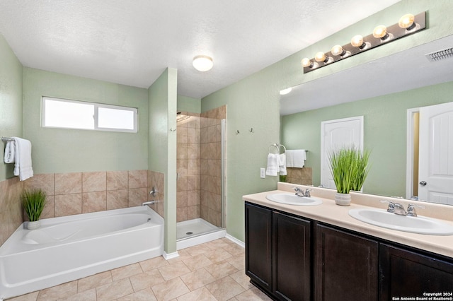 bathroom with vanity, tile patterned flooring, plus walk in shower, and a textured ceiling