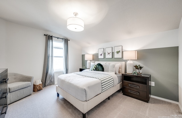 bedroom with light carpet and vaulted ceiling