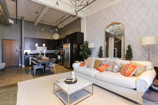 living room with beam ceiling and a high ceiling