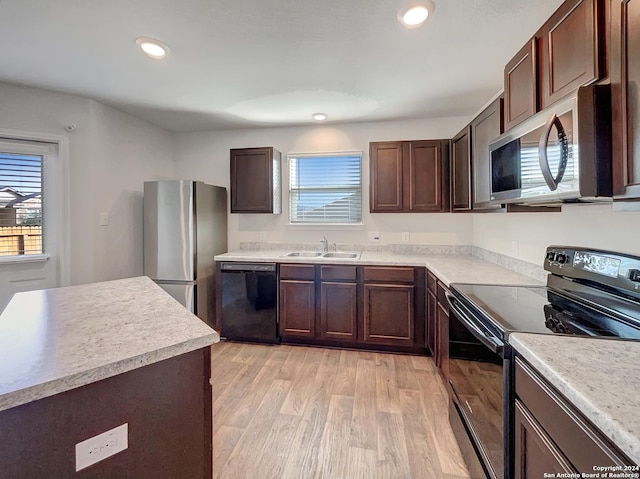 7502 Hercules Pt, San Antonio, TX 78252 - kitchen featuring black appliances, a sink, light wood-style floors, dark brown cabinets, and light countertops