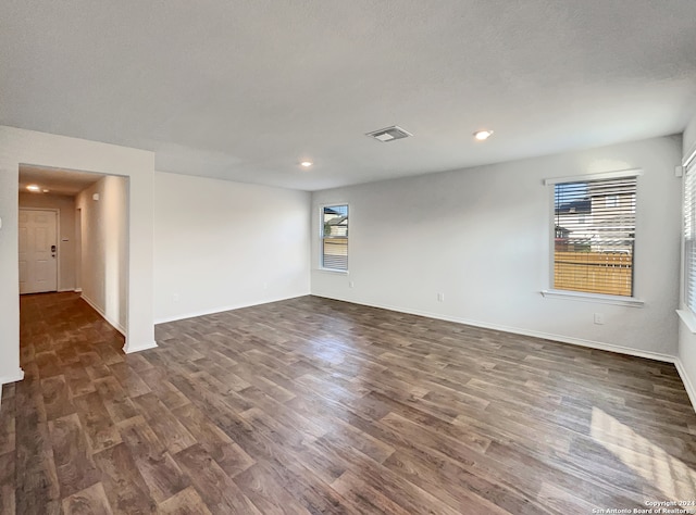 empty room featuring dark hardwood / wood-style flooring and a textured ceiling