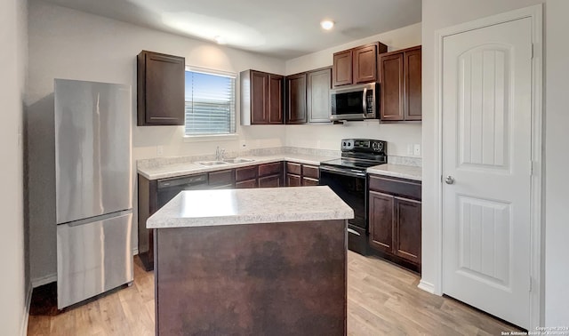 7502 Hercules Pt, San Antonio, TX 78252 - kitchen with stainless steel appliances, a sink, light wood-type flooring, dark brown cabinets, and a center island