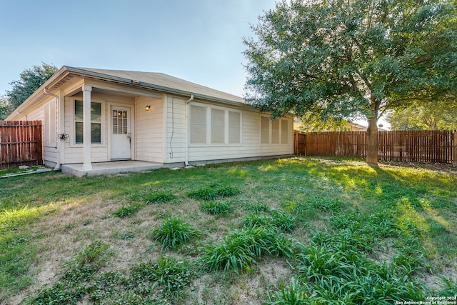 rear view of property featuring a yard